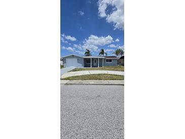 Charming single-story home featuring a covered front porch with classic white columns and an attached garage at 3741 Baden Dr, Holiday, FL 34691