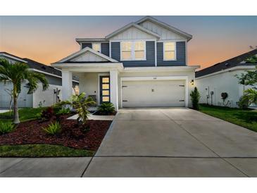 Charming two-story home featuring a well-manicured lawn, covered porch and a two car garage at 5437 Del Coronado Dr, Apollo Beach, FL 33572