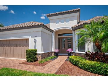 Charming home featuring a neutral color palette, tiled roof, manicured landscaping, and a brick walkway at 11411 Juglans Dr, Odessa, FL 33556