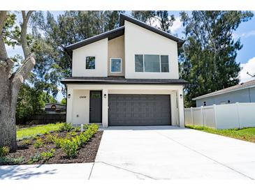 Modern two-story home featuring a gray garage door, well-manicured landscaping and a light-colored exterior at 12484 Cross St, Largo, FL 33773