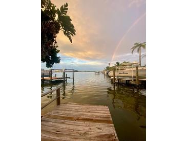 Scenic waterfront view with a rainbow, docks, boats, and calm waters creating a serene and inviting atmosphere at 14555 N Bayshore Dr, Madeira Beach, FL 33708