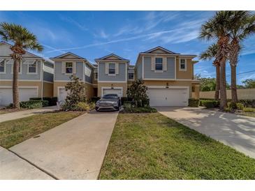 Charming townhomes featuring two-car garages, beautiful landscaping, and inviting curb appeal with lovely palm trees at 2013 Sunset Wind Loop, Oldsmar, FL 34677