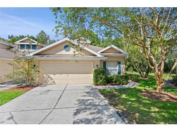 Charming single-Gathering home featuring a two-car garage, manicured landscaping and neutral exterior paint at 20221 Vintage Oaks Pl, Tampa, FL 33647
