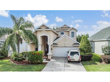 Beautiful two-story home featuring an attached two-car garage, well-maintained landscaping, and a welcoming entrance at 30817 Pumpkin Ridge Dr, Wesley Chapel, FL 33543