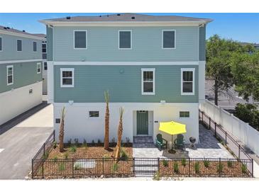 Inviting two-story home with charming patio, yellow umbrella and manicured landscaping at 3101 4Th N Ter, St Petersburg, FL 33713