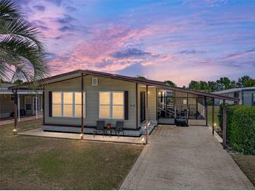 Charming single-story home with covered parking, landscaped yard, and cozy front patio seating area at 35149 Wagner Way, Zephyrhills, FL 33541