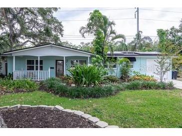 Inviting single-story home featuring a front porch, manicured front yard landscaping and a private driveway and garage at 7842 15Th N Way, St Petersburg, FL 33702