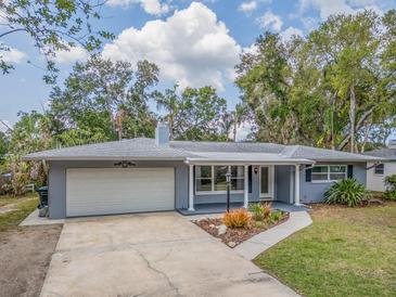 Charming single-story home with a well-manicured lawn and an attached two-car garage at 949 Virginia St, Dunedin, FL 34698