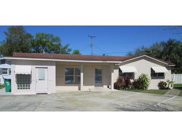 Charming single-story home with ample parking, awnings, and well-maintained landscaping at 10701 Village Green Ave, Seminole, FL 33772