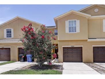 Charming townhome with a well-maintained lawn and a beautiful flowering tree in front of the property at 1984 Hawks View Dr, Ruskin, FL 33570