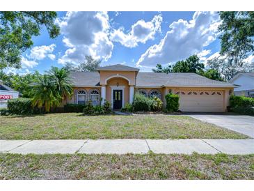 Charming single-story home featuring a stucco exterior, arched windows, and a well-maintained front yard at 2117 Laindale Pl, Valrico, FL 33596