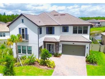 Stunning two-story home featuring a tile roof, brick driveway, and an attached two-car garage at 29895 Picana Ln, Wesley Chapel, FL 33543