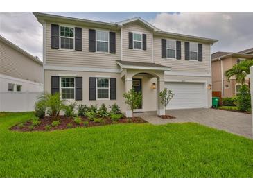 Charming two-story home boasts a well-manicured lawn, dark shutters, and an attached two-car garage at 3616 W Platt St, Tampa, FL 33609