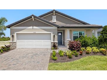 Charming single-Gathering home boasts a two-car garage and beautifully landscaped front yard at 11520 Myakka Blue Dr, Venice, FL 34293