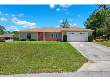 Inviting single-story home with a manicured lawn and a two-car garage at 13040 Hanley Dr, Spring Hill, FL 34609