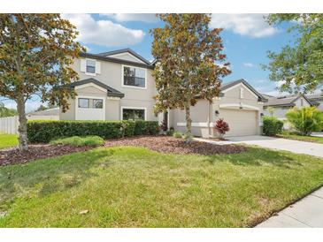Charming two-story home featuring manicured lawn, mulched beds and attached two car garage at 21834 Southern Charm Dr, Land O Lakes, FL 34637