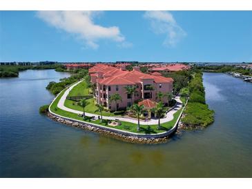 Stunning aerial view of waterfront condos with red tile roofs and lush landscaping in a beautiful community at 2755 Via Capri # 1223, Clearwater, FL 33764