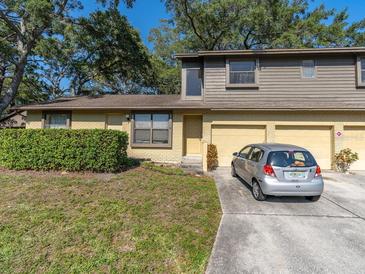 Two-story home with brick and wood exterior, two car garage, and a well-maintained front yard at 533 E Curlew Pl # 533, Tarpon Springs, FL 34689
