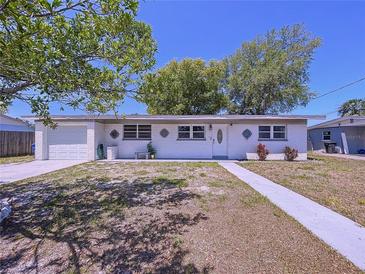 Charming single-story home with a white painted brick facade, attached garage, and simple, tidy landscaping at 5806 Liverpool Dr, Tampa, FL 33615