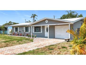 Charming single-story home featuring a brick walkway, covered entry, and well-maintained landscaping at 8240 Quail Rd, Seminole, FL 33777