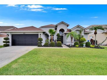Beautiful home featuring an attached garage and a well-manicured lawn with elegant landscaping at 8915 Hannigan Ct, Tampa, FL 33626