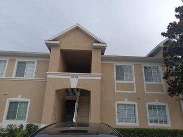 Inviting two-story condo with neutral exterior, covered entryway, and large windows allowing natural light at 9519 Amberdale Ct # 202, Riverview, FL 33578
