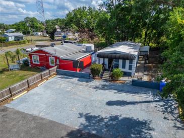 An aerial view shows the building and its parking spaces, surrounded by lush trees at 126 Ridgewood Ave, Brandon, FL 33510
