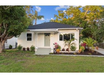 Charming single-story home with inviting front porch and landscaped front yard at 1443 Paloma Ln, Dunedin, FL 34698