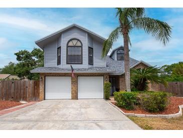 Charming two-story home featuring a two-car garage, landscaped yard, and beautiful architectural details at 3177 Montrose Pl, Palm Harbor, FL 34684