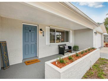 Charming front porch with seating area, planter, and stylish blue front door at 5620 Perkin Dr, New Port Richey, FL 34652
