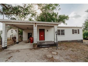 Charming single-story home featuring a covered carport, bright red front door and simple landscaping at 601 N Franklin St, Plant City, FL 33563