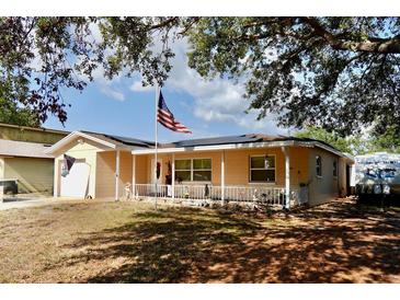 Charming single-story home featuring a front porch, tidy landscaping and an American flag at 8039 83Rd N St, Seminole, FL 33777