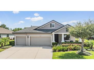 Charming single-story home featuring a three-car garage, manicured landscaping, and classic architectural details at 19837 Lonesome Pine Dr, Land O Lakes, FL 34638