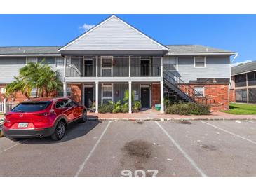 Charming two-story condo building with gray siding, brick accents, and convenient parking available at 200 Country Club Dr # 906, Largo, FL 33771