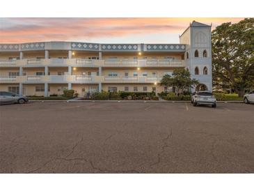 Lovely exterior of the condo building with unique tower feature and large parking lot at 2221 Swedish Dr # 55, Clearwater, FL 33763