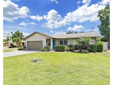Charming single-story home featuring a well-manicured lawn and tropical landscaping at 4175 20Th N St, St Petersburg, FL 33741