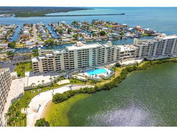 Expansive aerial view of condo complex with a pool, beach, and waterfront access on a sunny day at 6009 Sea Ranch Dr # 107E, Hudson, FL 34667