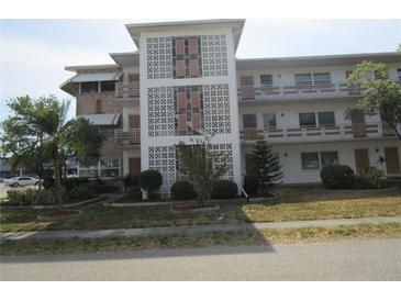 Attractive three-story condo building featuring decorative concrete block, balconies, and professional landscaping at 6015 19Th N St # 301, St Petersburg, FL 33714