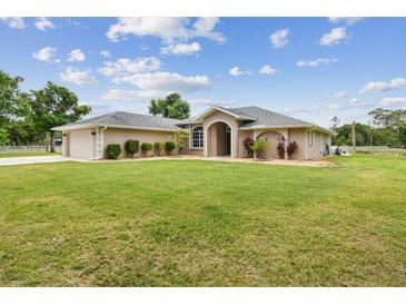 Charming ranch-style home with a lush green lawn and a well-maintained landscape, perfect for outdoor enjoyment at 6080 Taneytown St, North Port, FL 34291