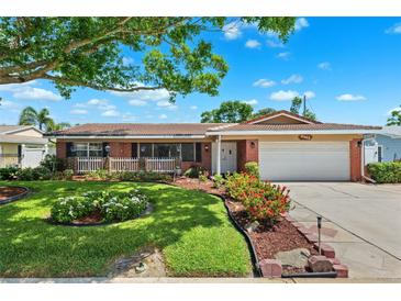 Charming single-story brick home featuring a well-manicured lawn and beautiful landscaping at 6365 32Nd N Ave, St Petersburg, FL 33710