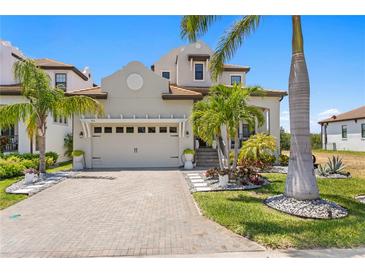 Beautiful home with a two-car garage, manicured landscaping, and a brick driveway at 916 Seagrape Dr, Ruskin, FL 33570