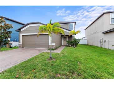 Charming single-Gathering home showcasing a well-maintained lawn and a cozy front entrance with beautiful landscaping at 11871 Crestridge Loop, Trinity, FL 34655
