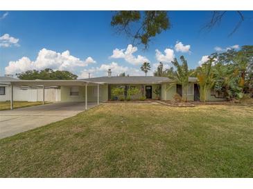 Charming single-story home with a well-maintained lawn and a convenient carport at 1450 Palmetto St, Clearwater, FL 33755