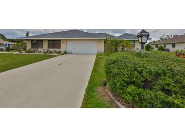 Charming single-story home with an attached garage and tidy landscaping at 1915 W Del Webb Blvd, Sun City Center, FL 33573