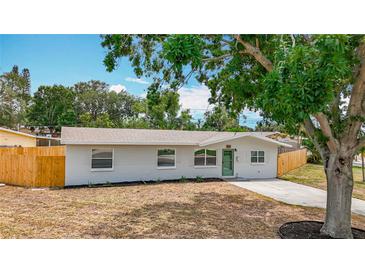 Charming single-story home featuring a well-maintained lawn, light colored paint, and a quaint green door at 200 Lewis Se Blvd, St Petersburg, FL 33705