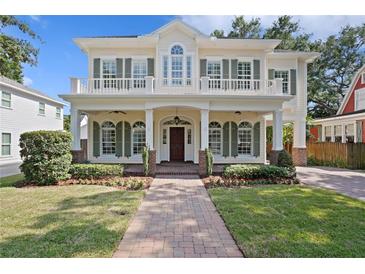 Charming two-story home with a welcoming front porch, balcony, and lush landscaping at 2714 W Jetton Ave, Tampa, FL 33629
