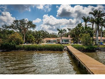 Waterfront property with expansive backyard, lush landscaping, and private dock at 2834 Pelham N Rd, St Petersburg, FL 33710