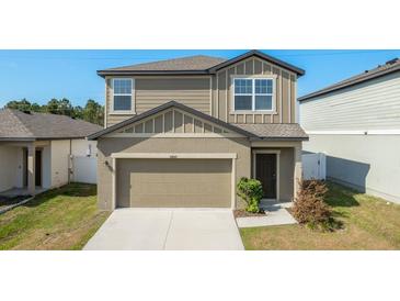 Charming two-story home featuring a two-car garage, well-maintained lawn, and attractive modern architecture at 34847 Daisy Meadow Loop, Zephyrhills, FL 33541
