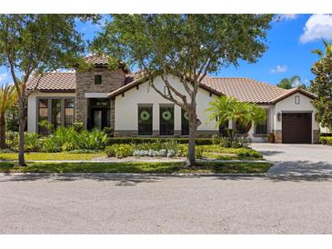 Beautiful single-story home with lush landscaping, stone accents, and a well-manicured lawn at 8434 Dunham Station Dr, Tampa, FL 33647
