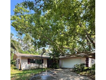 Charming single-story home with attached garage and mature trees in a quiet neighborhood at 977 Gershwin Dr, Largo, FL 33771